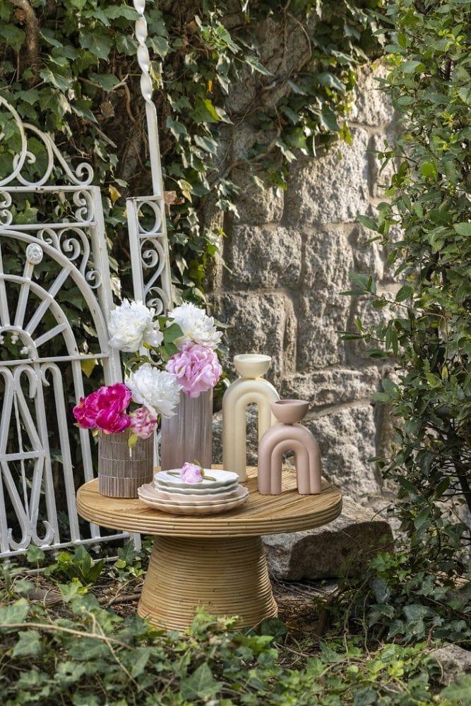 Mesa de madera en jardín con artículos decorativos de Maisons du Monde
