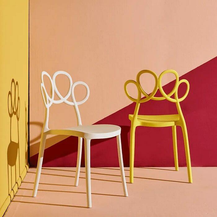 Dos sillas de plástico de color blanco y amarillo con respaldo de diseño moderno