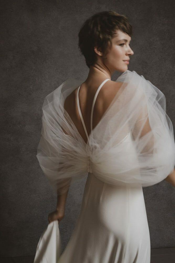 Modelo con un vestido de novia blanco con tejido etéreo
