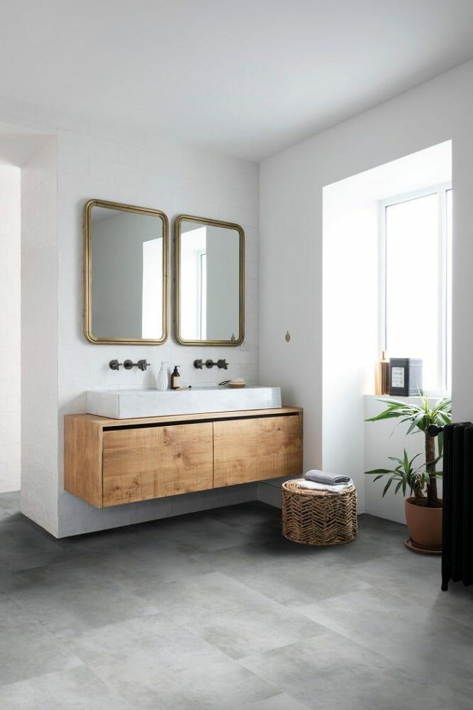 Interior de aseo con un lavabo doble de madera con dos espejos