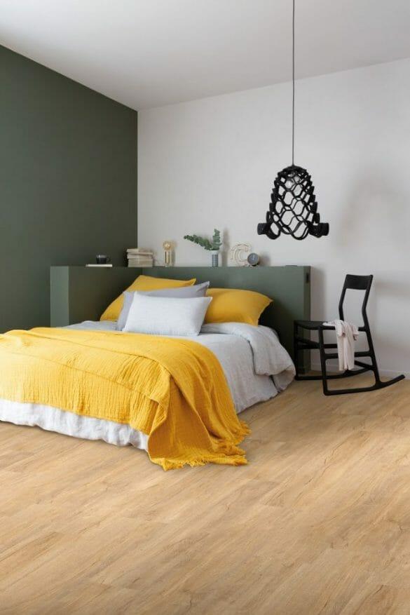 Habitación moderna con cama con textil blanco y amarillo y lámpara colgada