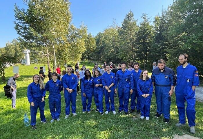 Grupo de jóvenes profesionales con mono azul para hacer pruebas en el espacio