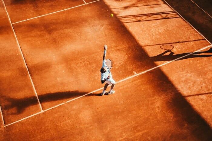 Hombre en la pista de tenis jugando