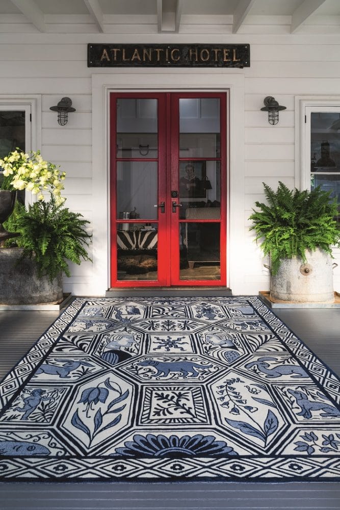 Puerta roja con una alfombra de diseño colorida