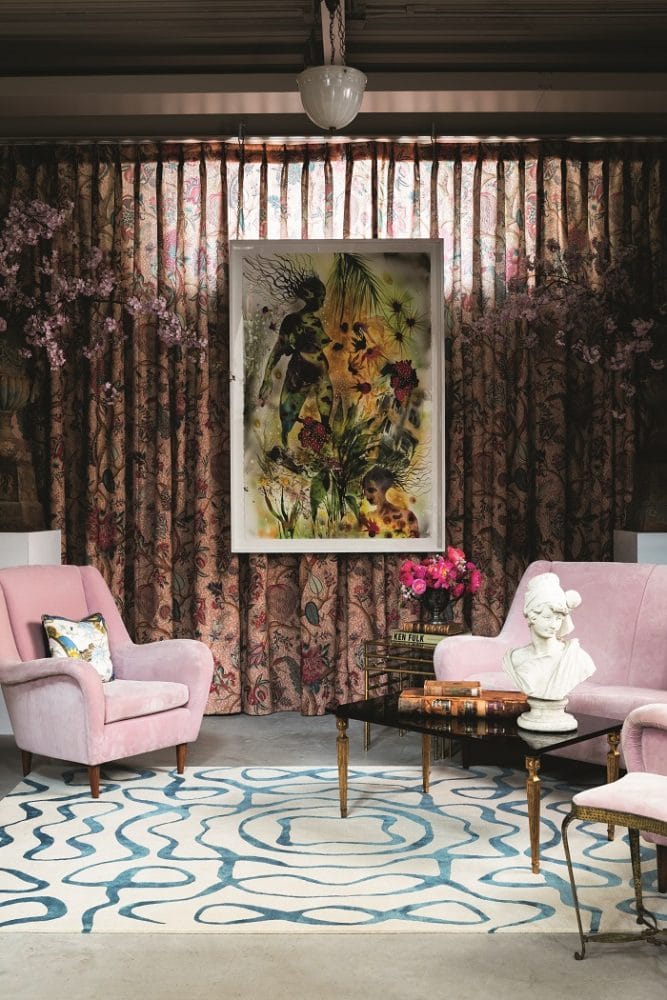 Zona de salón con dos sillones rosas con alfombra de diseño