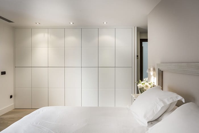 Dormitorio con un armario blanco hecho a medida