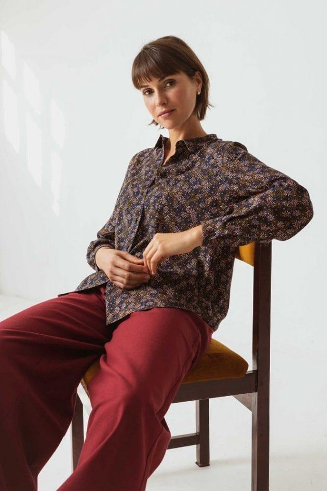 Modelo sentada con una camisa floreada de los años 70