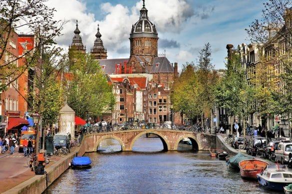 Vista de una iglesia con un río con puente de Ámsterdam
