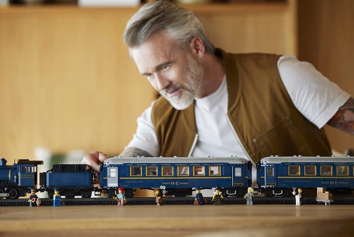 Hombre jugando con el tren de LEGO Orient Express