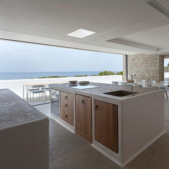 Interior de una villa moderna con una cocina con vistas al mar con correderas minimalistas