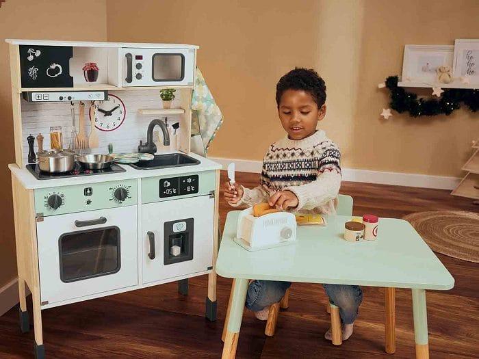 Niño jugando con una cocina de Lidl de madera