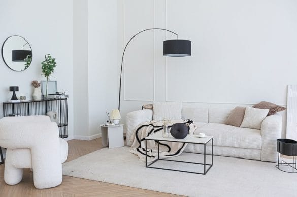Salón con sofá blanco, alfombra y lámpara de pie