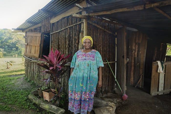 Mujer en Honduras a las puertas de su casa
