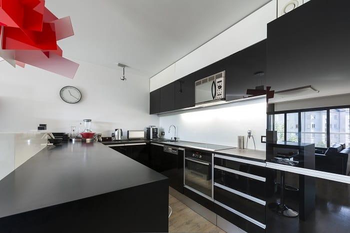 Cocina moderna negra con electrodomésticos integrados en los muebles de la cocina