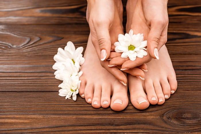 Manos y pies limpios con unas flores blancas