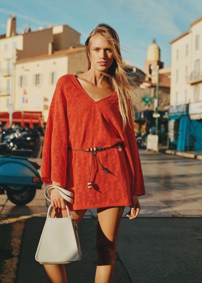 Modelo con un vestido de verano rojo y un bolso Longchamp