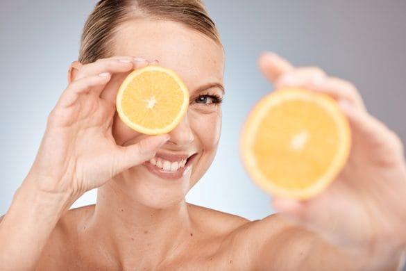mujer con naranja tratamiento facial