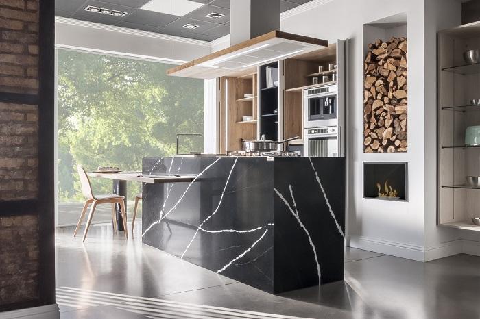 Diseño de una cocina blanca con isla en color negro tipo mármol con un taburete