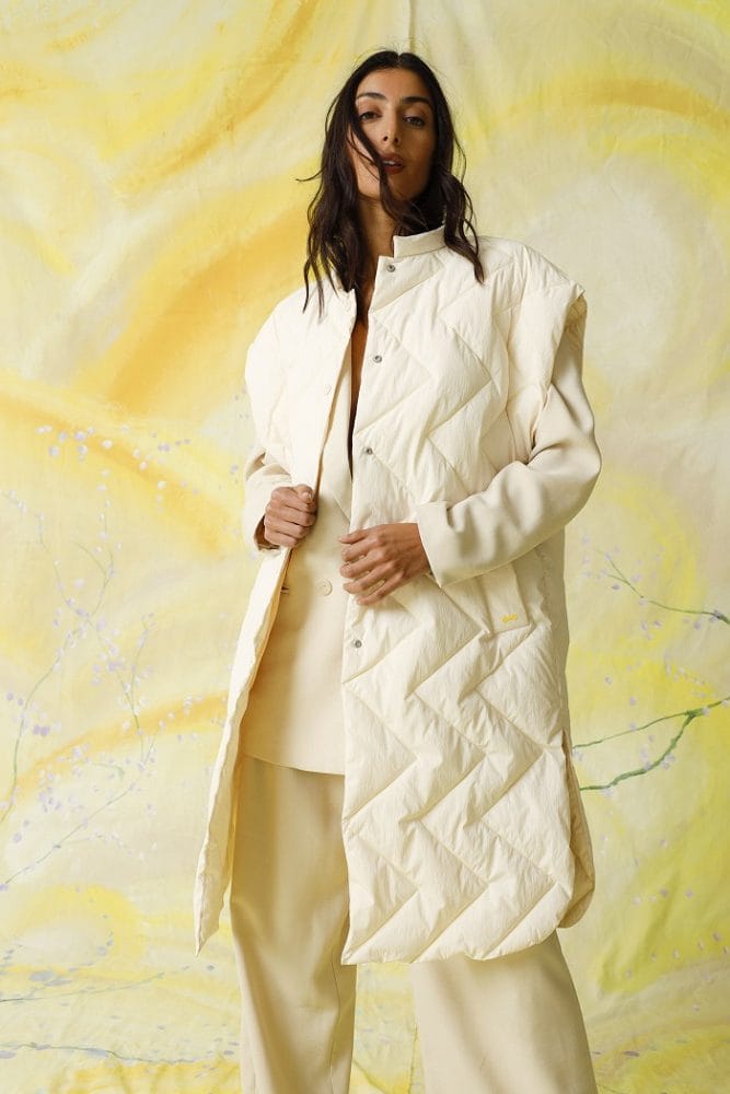 Modelo con un abrigo blanco sostenible y reciclado