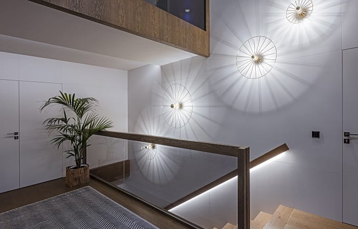 Pasillo con escaleras con una iluminación en la pared de decoración