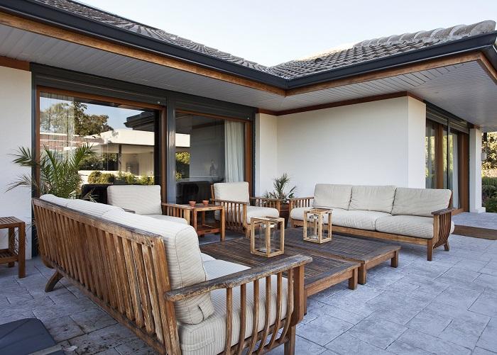 Terraza con sofás de madera y cojines color blanco