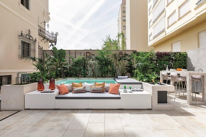 Terraza zona exterior en Casa Decor 2024 con piscina y grandes sofás con cojines