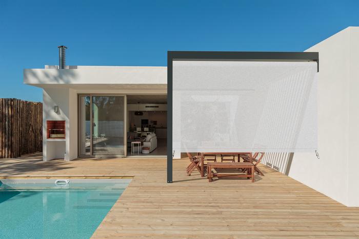 toldo lateral cortina blanco en terraza con piscina