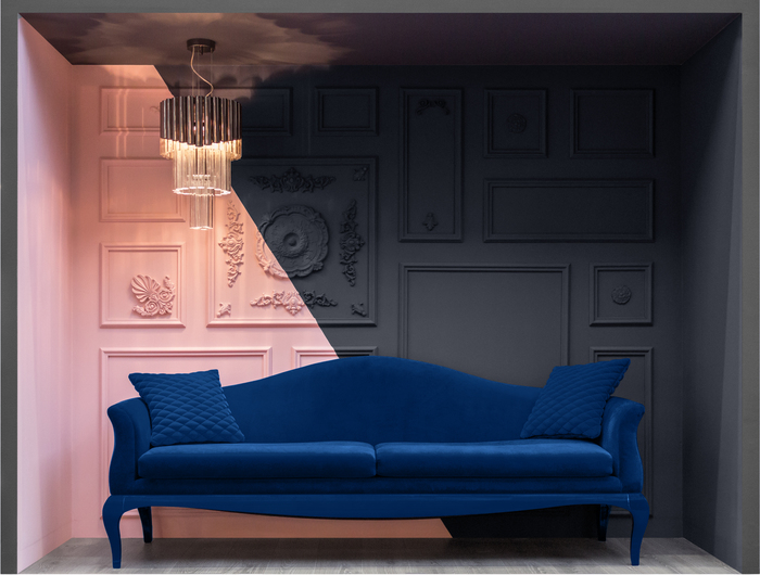 pared rosa con relieve y sofá azul brillante